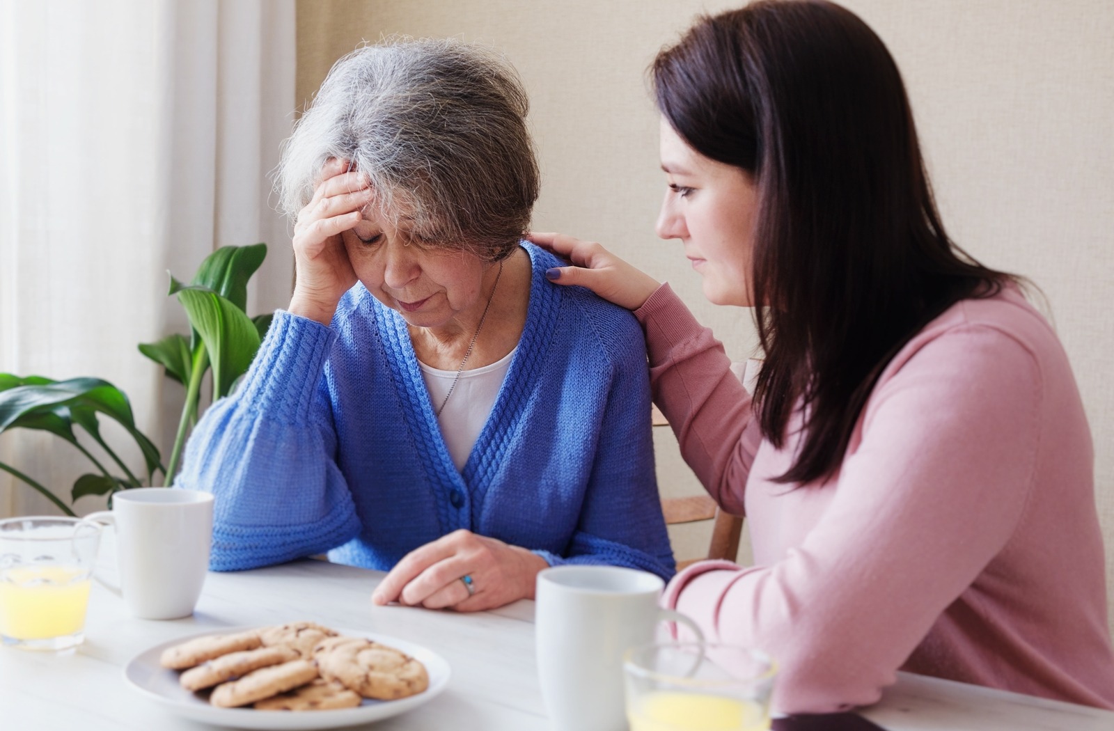 A young caregiver offers support to a senior with Alzheimer's.