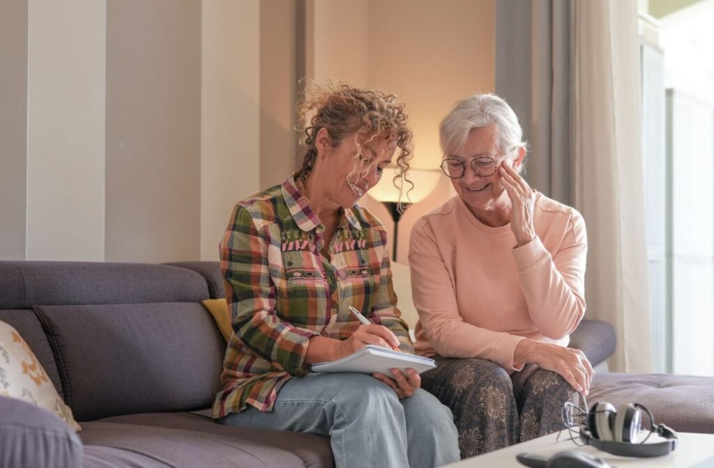 An adult child helps their older parent understand a legal document while sitting together on the couch